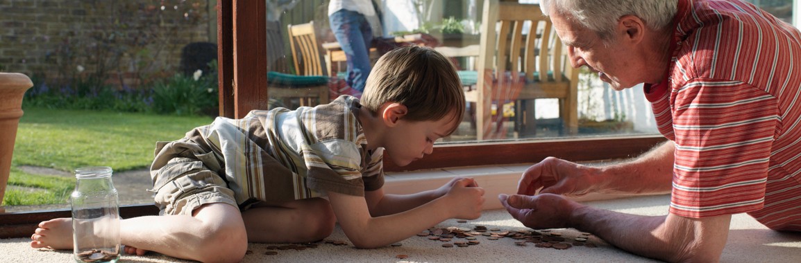 Grandad and grandson counting coins, teaching about superannuation.